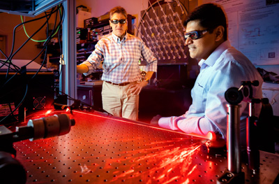 Prasad Iyer, right, and Igal Brener demonstrate optical hardware for beam steering tests.