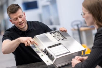 A Trumpf employee shows where a battery will be cut open by laser.